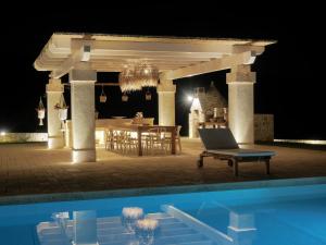 een paviljoen met een tafel en een zwembad in de nacht bij Trulli Terra Viva in Alberobello