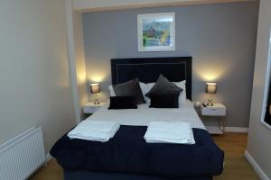 a bedroom with a large bed with two towels on it at Causeway B&B in Bushmills