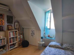 sypialnia z łóżkiem i półką na książki w obiekcie Chambre proche paris JO 2024 w mieście Chaumontel