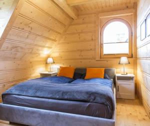 ein Schlafzimmer mit einem Bett in einem Holzzimmer in der Unterkunft Domek VIP PIETIA in Zakopane
