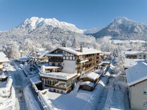 un resort nella neve con montagne sullo sfondo di Hotel Filser a Oberstdorf