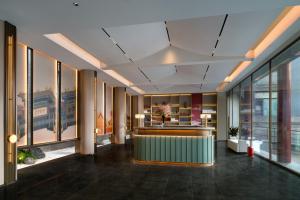 an office lobby with a counter and windows at SSAW Garden Hotel Beijing in Beijing