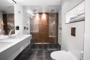 uma casa de banho branca com um chuveiro e um WC. em Panorama Hotell & Resort em Steinsland