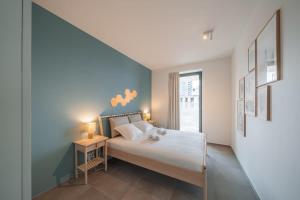 En eller flere senge i et værelse på Huswell - Modern new apartment with pool access and parking