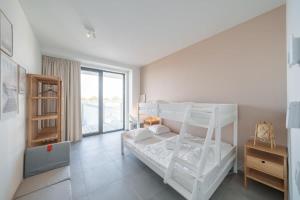 En eller flere senge i et værelse på Huswell - Modern new apartment with pool access and parking