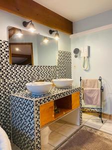 a bathroom with two sinks and a mirror at Les Chambres d'Ovaline in Saint-Émilion