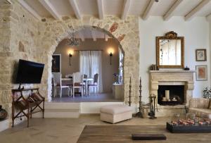 a living room with a stone wall and a fireplace at Olive House Traditional Villa with Pool in Sitia