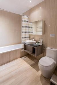 曼谷的住宿－素可泰住魯安呂迪旅館，浴室配有卫生间、盥洗盆和浴缸。
