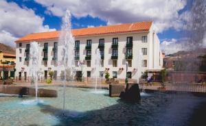 a building with water fountains in front of a building at Xima Exclusive Cusco in Cusco