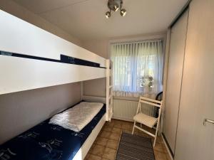 Dormitorio pequeño con litera y silla en Heggerank 19A*, en Nieuwvliet