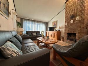 sala de estar con sofá y chimenea en Heggerank 19A*, en Nieuwvliet