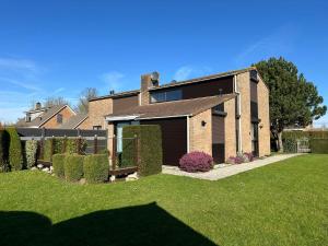 una casa de ladrillo con garaje en un patio en Heggerank 19A*, en Nieuwvliet