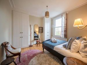 1 dormitorio con cama y ventana en Pass the Keys Stylish London Flat near Station - Victoria 20 min, en Londres