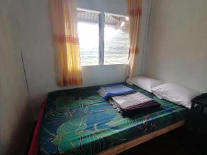 a small bed in a room with a window at BATAD CRISTINA'S Main Village INN & Restaurant in Banaue
