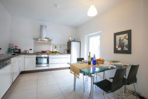 uma cozinha branca com uma mesa e cadeiras em Franklin House - Happy Rentals em Lugano