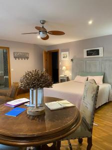 ein Wohnzimmer mit einem Bett und einem Tisch mit einem sidx sidx in der Unterkunft Les Chambres d'Ovaline in Saint-Émilion
