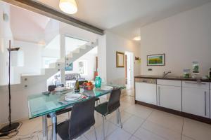 uma cozinha com mesa e cadeiras num quarto em Franklin House - Happy Rentals em Lugano