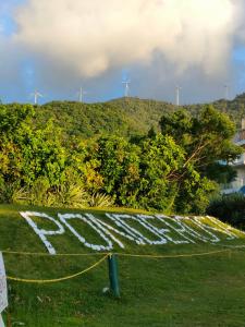 a sign in a field with wind turbines in the background at Puerto Galera Transient Guest Room in Puerto Galera