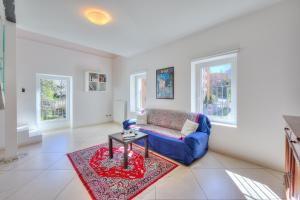 uma sala de estar com um sofá azul e um tapete vermelho em Franklin House - Happy Rentals em Lugano