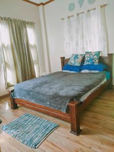 a bedroom with a large bed with blue pillows at Puerto Galera Transient Guest Room in Puerto Galera