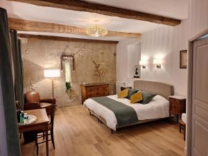 1 dormitorio con 1 cama, 1 mesa y 1 silla en Manoir du Bellay en Montreuil-Bellay