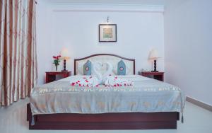 a bedroom with a bed with red roses on it at Silver Mounts Hotel in Phnom Penh
