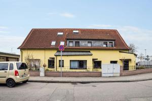 une maison jaune sur le côté d'une rue dans l'établissement Nice Apartments in Hanau, à Hanau
