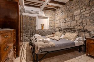 ein Schlafzimmer mit einem Bett und einer Steinmauer in der Unterkunft IL RICHIASTRO MEDIEVALE in Viterbo