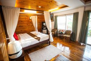 a bedroom with a bed with a wooden wall at Maekhong Delta Boutique Hotel in Mae Sai