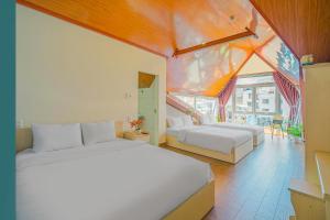 a large bedroom with two beds and a balcony at Nắng Chiều Central Hotel in Da Lat