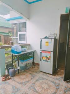 a kitchen with a refrigerator and a table at Puerto Galera Transient Guest Room in Puerto Galera