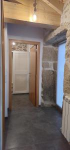 a hallway with a door and a stone wall at Casa do Rio - AL in Valença
