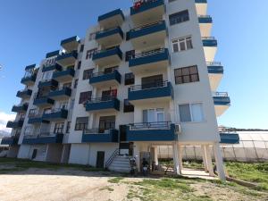 加濟帕夏的住宿－Gazipasa/Alanya Airport Apt 5minBEACH/5minAIRPORT，海滩上带蓝色阳台的公寓大楼