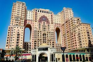 a large building with a clock on the front of it at Manzil - Studio Apartment in Dubai Silicon Oasis near Dubai Outlet Mall in Dubai
