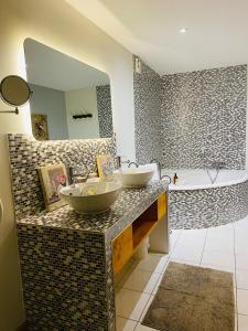 a bathroom with two sinks on a counter with a tub at Les Chambres d'Ovaline in Saint-Émilion