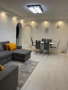 uma sala de estar com um sofá e uma mesa com cadeiras em Best Apartment Augsburg em Augsburg