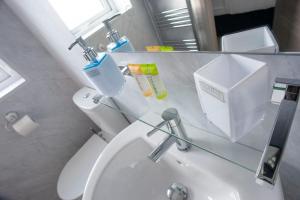 uma casa de banho com um lavatório branco e um espelho. em Causeway guest accommodation em Bushmills