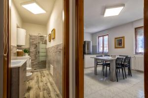 una cucina e una sala da pranzo con tavolo e sedie di White lilium apartment - Magnolia holidays ad Alghero