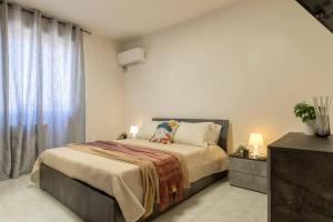 una camera con un grande letto e una finestra di White lilium apartment - Magnolia holidays ad Alghero
