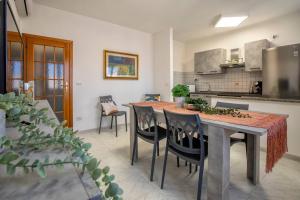 una cucina con tavolo e sedie in una stanza di White lilium apartment - Magnolia holidays ad Alghero