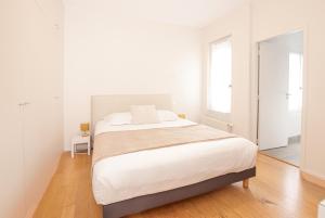 - une chambre blanche avec un lit et un miroir dans l'établissement Appartement T2 de Luxe face au Jardin Public, à Bordeaux