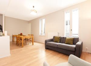 - un salon avec un canapé et une table dans l'établissement Appartement T2 de Luxe face au Jardin Public, à Bordeaux