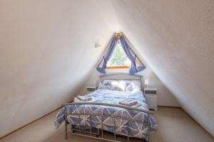 a small bedroom with a bed in a attic at Chalet 106 in Deal