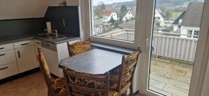 希登豪森的住宿－Sson FeWo，一个带桌子的厨房和一个享有阳台景色的厨房