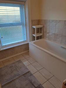 a large bathroom with a tub and a window at Drogheda Townhouse in Drogheda