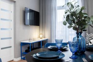 a dining room table with a blue vase on it at Apartament Indygo16 in Kalisz