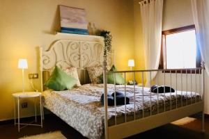 1 dormitorio con 1 cama con almohadas verdes en Can Ranqueta: Private Finca mit Pool, Außenküche und Barbecue, en Es Carritxo