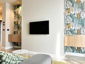 a living room with a tv on a wall at Pepe's Home B&B in Nichelino