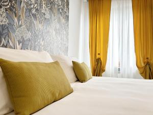 1 dormitorio con cama blanca y cortinas amarillas en Pepe's Home B&B, en Nichelino