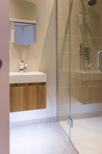La salle de bains est pourvue d'un lavabo et d'une douche. dans l'établissement Madison Hill - Byrne Garden 1 - Two bedroom home, à Londres